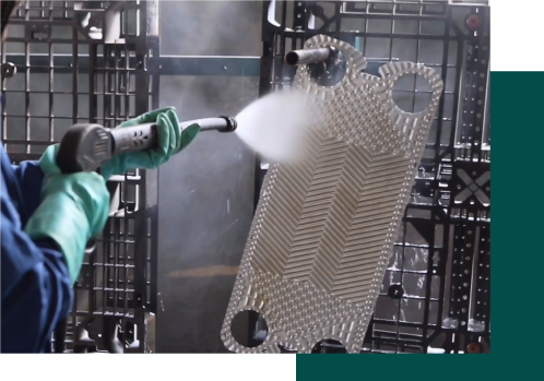 Operario de AMD realizando la limpieza con agua a presión de una placa de intercambiador